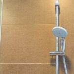 Coloană de duș fixată pe perete în baie.