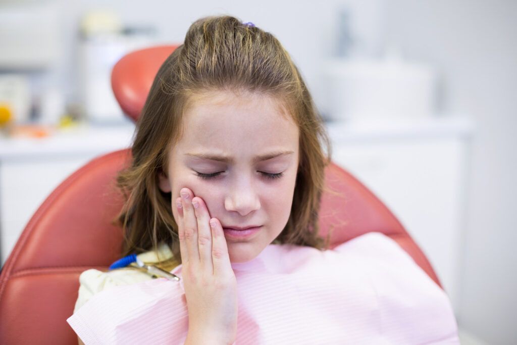 Copil la dentist pentru o durere la măsea.